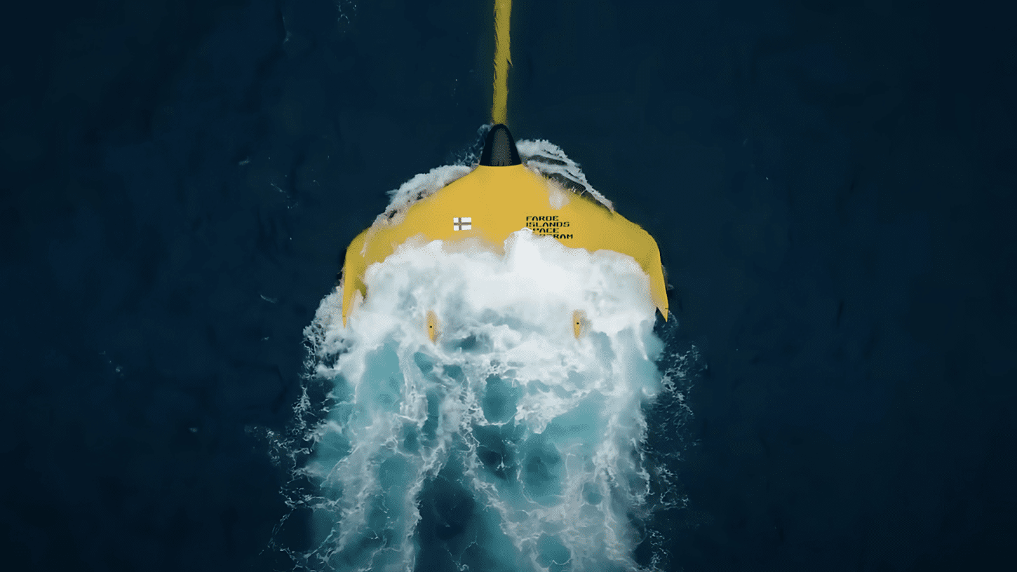 Top-down view of a bright yellow tidal kite from the Faroe Islands Space Program gliding through ocean currents, showcasing lunar-powered energy generation.