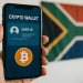 Smartphone showing crypto wallet screen with Bitcoin icon and blurred user ID, held in front of a South African flag — FATF Travel Rule context.