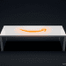 A sleek white smart table surface featuring a glowing orange Amazon smile logo surrounded by minimalist geometric etched patterns.