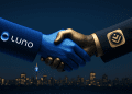 A 3D handshake between Luno and Discovery Bank, featuring the official Luno logo and Discovery Bank app icon on each sleeve, set against a clean Johannesburg night skyline.
