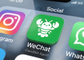 A smartphone screen showing the WeChat app icon customized with the white ClawBot lobster logo, representing Tencent's AI agent integration.