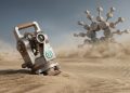 A precision mechanical theodolite with the green TapTools logo and an engraving 'Calibrated for Cardano' is set against a clean desert landscape, with a colossal, golden Cardano logo monument in the distant background under a clear sky.