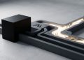A minimalist 3D editorial graphic showing a heavy matte black block obstructing a grey circuit path, which reroutes into a glowing alternative channel, symbolising tech decoupling, the Huawei mirror effect, and the US Anthropic blackout backfire.