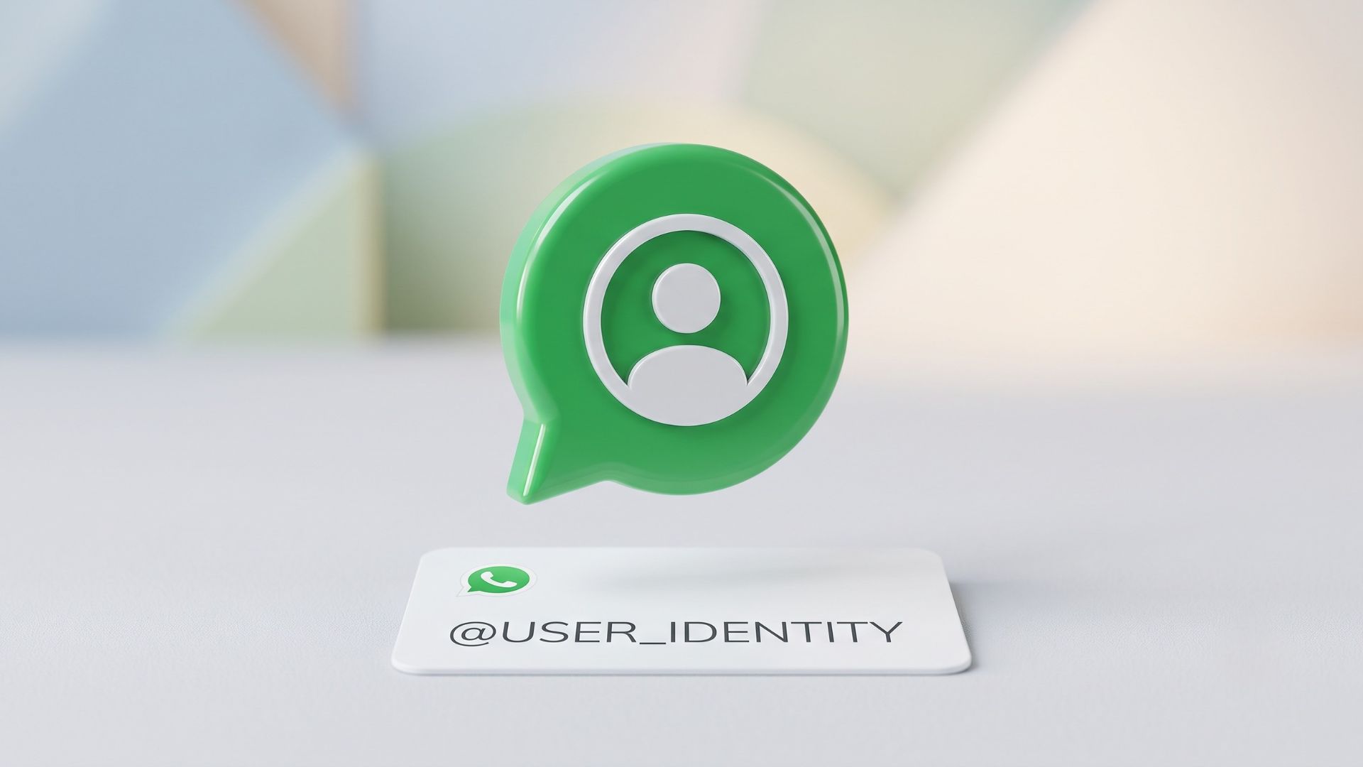 A minimalist 3D editorial graphic of a green chat bubble containing a user icon, hovering over a clean white card with '@USER_IDENTITY' to symbolise WhatsApp rolling out usernames for enhanced user privacy.