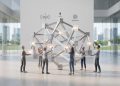 A 3D render representing Web 3.0 and open public AI infrastructure, featuring a central geometric structure collaboratively assembled in a minimalist studio.